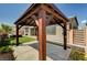 Wooden gazebo in backyard with lush plants, synthetic grass and view of the home at 9638 Smiley Creek St, Las Vegas, NV 89178
