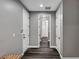 Hallway with modern gray walls, dark wood-style floors, and access to a closet with built-in shelving at 9638 Smiley Creek St, Las Vegas, NV 89178