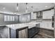 Open kitchen with white cabinets, stainless appliances, island sink, and modern pendant lights at 9638 Smiley Creek St, Las Vegas, NV 89178