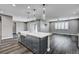 Modern kitchen features dark cabinets, quartz countertops, farmhouse sink, and pendant lighting at 9638 Smiley Creek St, Las Vegas, NV 89178