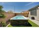 Backyard swimming pool is surrounded by a stone border, artificial grass, and privacy walls at 9638 Smiley Creek St, Las Vegas, NV 89178