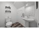 Bathroom featuring a pedestal sink, modern wood-look flooring, and shelving accents at 9715 Harper Edge St, Las Vegas, NV 89143