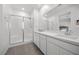 Modern bathroom with dual sinks, white cabinets, and a glass-enclosed shower at 9715 Harper Edge St, Las Vegas, NV 89143