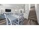 Open-concept dining area with hardwood floors, next to the living room and modern staircase at 9715 Harper Edge St, Las Vegas, NV 89143