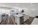The open-concept living space has a kitchen with a island, and a living room with a blue couch at 9715 Harper Edge St, Las Vegas, NV 89143