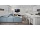 Open floor plan living room and kitchen showcasing wood floors, a large sofa, and breakfast bar seating at 9715 Harper Edge St, Las Vegas, NV 89143
