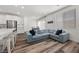 Open living area featuring modern decor, sleek wood flooring, and a spacious comfortable sofa with decorative pillows at 9715 Harper Edge St, Las Vegas, NV 89143