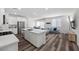 Modern open floor plan kitchen and living room with white cabinets, stainless appliances, and dining area at 9715 Harper Edge St, Las Vegas, NV 89143