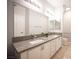 Bathroom featuring double sinks with granite countertops, large mirrors, and modern lighting at 10245 S Maryland Pkwy # 106, Las Vegas, NV 89183