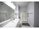 Modern bathroom featuring dual sinks, a vanity, and a tiled shower with glass doors at 10245 S Maryland Pkwy # 106, Las Vegas, NV 89183