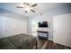 Well-lit bedroom with a ceiling fan, TV, and entry to the bathroom at 10245 S Maryland Pkwy # 106, Las Vegas, NV 89183