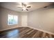 Neutral bedroom featuring wood-look flooring, a ceiling fan, and natural light from the window at 10245 S Maryland Pkwy # 106, Las Vegas, NV 89183