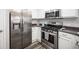 Modern kitchen featuring stainless steel appliances, gray countertops, and white cabinetry at 10245 S Maryland Pkwy # 106, Las Vegas, NV 89183
