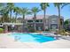 A sparkling community pool is surrounded by palm trees and attractive landscaping at 10245 S Maryland Pkwy # 106, Las Vegas, NV 89183