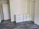 Stylish bedroom showcasing coordinating white furniture and wood-style flooring at 1050 Spotted Saddle St, Henderson, NV 89015