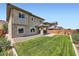 Beautiful backyard featuring a well-maintained lawn and a covered patio at 10693 Harvest Green Way, Las Vegas, NV 89135