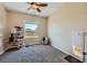 Bright bedroom with carpet flooring, a ceiling fan, and a large window at 10693 Harvest Green Way, Las Vegas, NV 89135