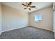This bedroom has neutral colored walls, carpeted floors, and a window with a view at 10693 Harvest Green Way, Las Vegas, NV 89135