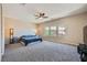 Spacious bedroom with carpet, a ceiling fan, and three windows overlooking the yard at 10693 Harvest Green Way, Las Vegas, NV 89135