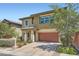 Two-story home with a two-car garage and mature trees, a brick driveway, and desert landscaping at 10693 Harvest Green Way, Las Vegas, NV 89135
