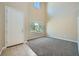 A bright and open living room with tile entry, carpet, and a tall window at 10693 Harvest Green Way, Las Vegas, NV 89135