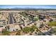 A high-angle aerial view showcasing the contemporary neighborhood design, lush landscaping, and scenic mountain views at 10895 Artesano Ave, Las Vegas, NV 89135