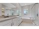 Bright bathroom featuring double sinks, a soaking tub, and a glass-enclosed shower at 10895 Artesano Ave, Las Vegas, NV 89135