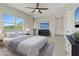 Bright bedroom featuring a ceiling fan, large windows, and sleek, modern furniture and decor at 10895 Artesano Ave, Las Vegas, NV 89135