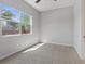 Bright, empty bedroom with a large window offering plenty of natural light and plush carpeting at 10895 Artesano Ave, Las Vegas, NV 89135