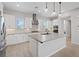 Bright kitchen featuring a large island, stainless steel appliances, white cabinets, and sleek countertops at 10895 Artesano Ave, Las Vegas, NV 89135