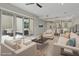 Bright living room with modern furniture, large sliding glass doors to patio, and open floor plan to kitchen at 10895 Artesano Ave, Las Vegas, NV 89135