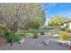A well-maintained backyard featuring grass, a fire pit, and desert landscaping at 11 Feather Sound Dr, Henderson, NV 89052