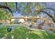 A lush backyard with green grass, mature trees, swing and trampoline offering a serene outdoor space at 11 Feather Sound Dr, Henderson, NV 89052