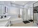 Bathroom featuring soaking tub, double sinks, and a glass block window at 11 Feather Sound Dr, Henderson, NV 89052