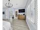 Bedroom with plantation shutters, mounted television, light wood floors, and an arch mirror at 11 Feather Sound Dr, Henderson, NV 89052