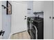A laundry room featuring a front loading washer and dryer and white cabinets for storage at 11 Feather Sound Dr, Henderson, NV 89052
