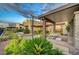 Beautifully landscaped backyard with covered patio, outdoor seating, and manicured garden at 2180 Skyline Heights Ln, Henderson, NV 89052