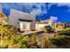 Lush backyard featuring desert landscaping and a covered patio with outdoor seating at 2180 Skyline Heights Ln, Henderson, NV 89052