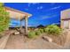 Inviting backyard patio with an open-air lounge, beautiful landscaping, and a scenic view at 2180 Skyline Heights Ln, Henderson, NV 89052