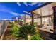 Well-maintained backyard with a covered patio, lush garden, and stone accents at 2180 Skyline Heights Ln, Henderson, NV 89052