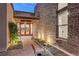 A modern home entrance featuring a stone wall, glass doors, and lush landscaping at 2180 Skyline Heights Ln, Henderson, NV 89052