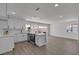 Modern, open kitchen with stainless steel appliances, laminate floors, white cabinets, breakfast bar, and view to the backyard at 2504 Paradise Village Way, Las Vegas, NV 89120