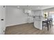 Contemporary kitchen boasting white cabinetry, modern appliances, breakfast bar seating, and new laminate flooring at 2504 Paradise Village Way, Las Vegas, NV 89120