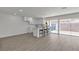 Bright living space with modern white kitchen, bar stool seating, new laminate floors, and sliding glass doors to a private backyard at 2504 Paradise Village Way, Las Vegas, NV 89120
