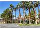 Inviting clubhouse exterior, landscaped with palm trees and grass, offers convenient parking spaces at 251 S Green Valley Pkwy # 721, Henderson, NV 89012