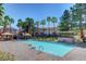 Sparkling community pool area with comfortable seating, lush palm trees, and a covered grilling area at 251 S Green Valley Pkwy # 721, Henderson, NV 89012
