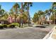 Gated community entrance with lush landscaping, palm trees, and well-maintained street at 251 S Green Valley Pkwy # 721, Henderson, NV 89012