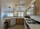 This kitchen has oak cabinets, gas range, and white countertops and is adjacent to a living area with a view outside at 251 S Green Valley Pkwy # 721, Henderson, NV 89012