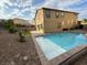 A backyard with a pristine private pool, hardscape and decorative rock, all surrounded by desert landscaping at 2947 Caxton Grove Dr, Henderson, NV 89052