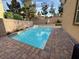 A backyard with a pristine private pool, hardscape and decorative rock, all surrounded by desert landscaping at 2947 Caxton Grove Dr, Henderson, NV 89052